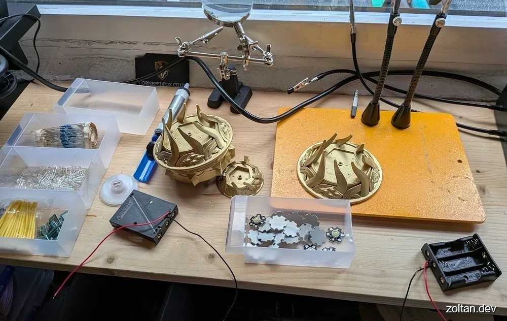 Workbench setup featuring 3D printed parts, resistors, LEDs and heat-shrink tubing ready for assembly.