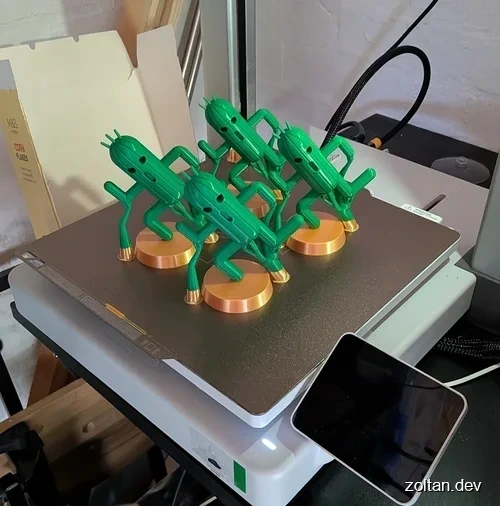 Four Green 3D-printed Cactuars on circular bases on a Bambu Lab A1 printer.
