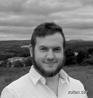 Handsome man in white shirt smiling outdoors with cloudy sky and landscape background.