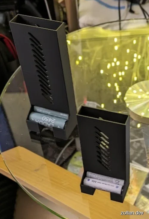 Two black 3D-printed battery holders.
