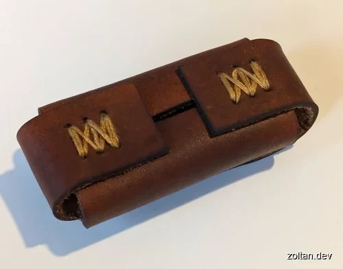 Brown leather case with gold thread stitching.