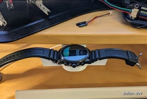 A smartwatch resting on a white stand.