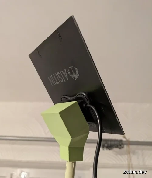 A small solar panel mounted on a green 3D printed stand.