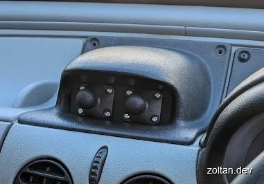 Close-up view of a vehicle's dashboard with two black RAM ball mounts, secured by screws.